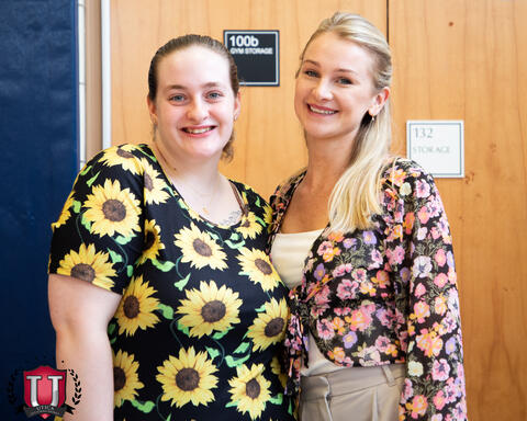 Two staff smiling and posing together