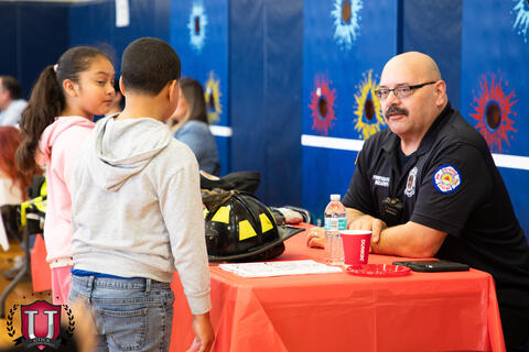 Students engaging and talking with a fire department table