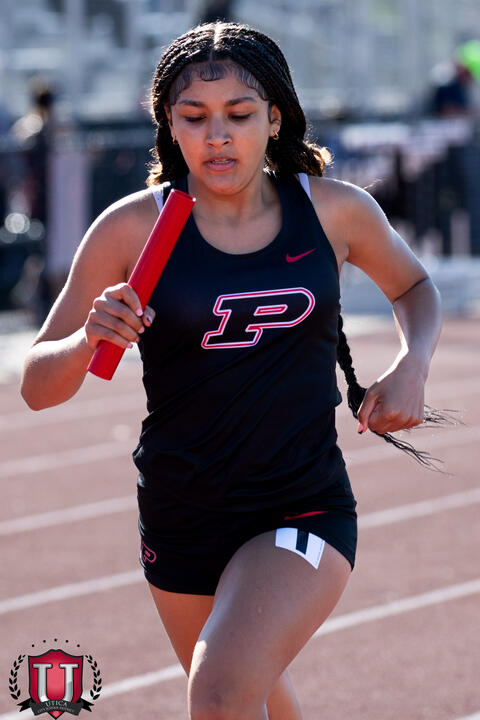 athlete running intently with baton