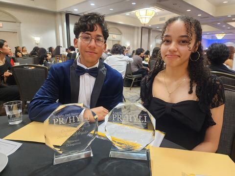 Two students posing at a table after receiving their awards