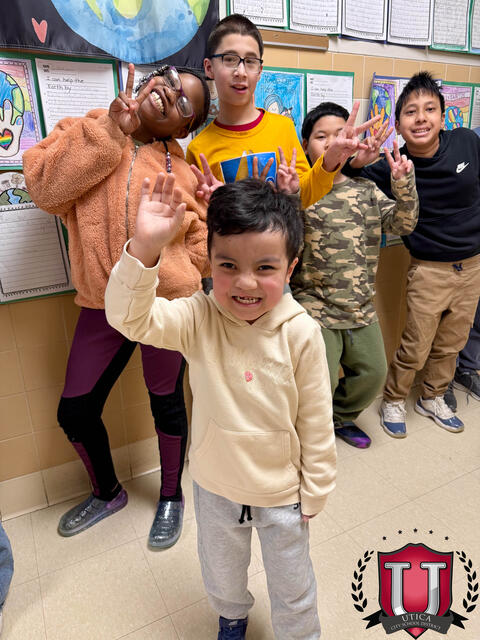 Student smiling with his hand in the air