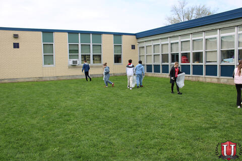 Students looking for trash near the building