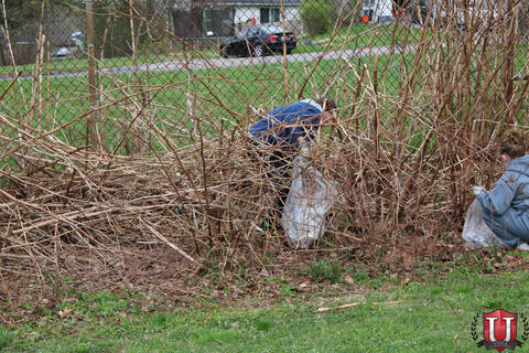 Students in the brush picking up trash