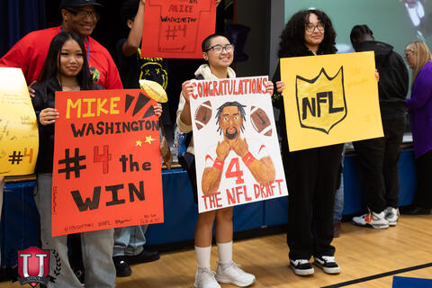 Students proudly holding up their posters
