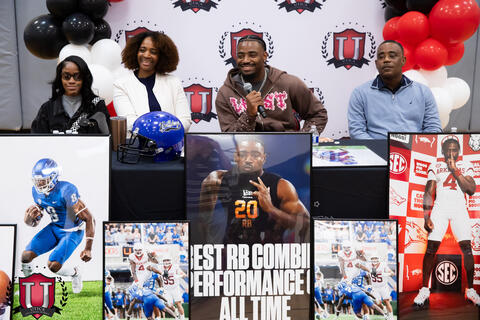 Mike answering questions at his table with a microphone