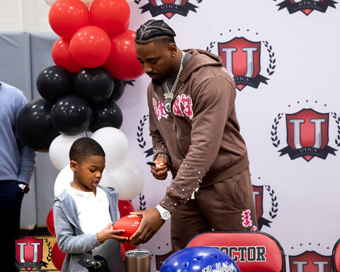 Mike giving a student a signed football