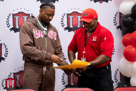 Mike signing something with a security guard
