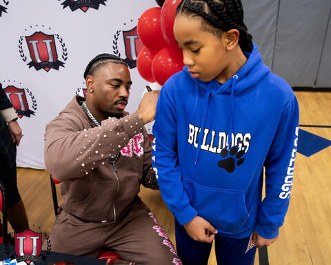 Mike signing a students hoodie 