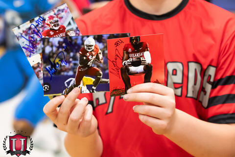 Student holding up a couple photos of mike
