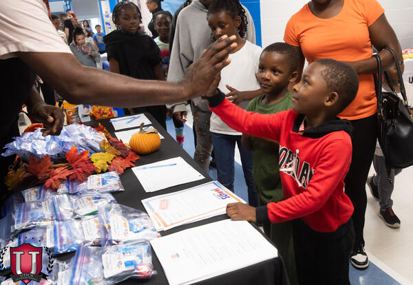 An elementary school student high fives an adult during the Watson Williams Elementary School Open House in September 2026.