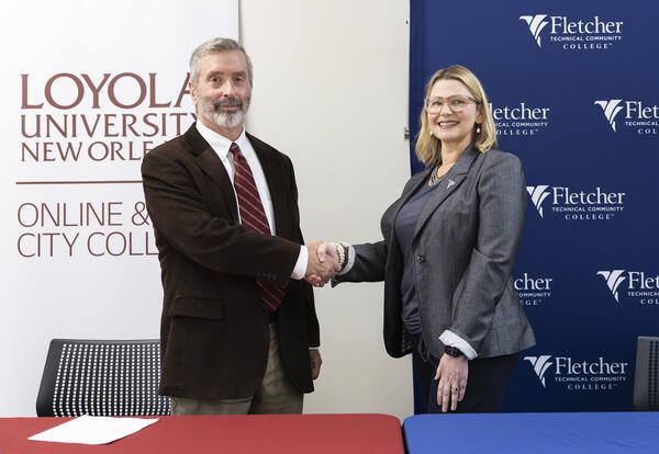 Dr. Paul Cesarini of Loyola University New Orleans and Dr. Carrie Cortez of Fletcher Technical Community College shake hands after signing a transfer partnership agreement between the two institutions.