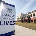Banner reading “75 Years of Changing Lives” displayed on the Fletcher Technical Community College campus in front of an academic building.