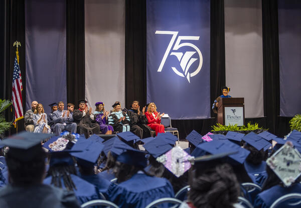 Dr. Kristine Strickland stands at the podium addressing graduates during Fletcher Technical Community College’s Spring 2026 Commencement Ceremony at the Warren J. Harang Jr. Municipal Auditorium in Thibodaux, while graduates and college leaders listen fro