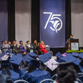 Dr. Kristine Strickland stands at the podium addressing graduates during Fletcher Technical Community College’s Spring 2026 Commencement Ceremony at the Warren J. Harang Jr. Municipal Auditorium in Thibodaux, while graduates and college leaders listen fro