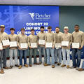 Eleven graduates of Fletcher Technical Community College’s 22nd Certified Line Worker Program cohort stand together holding their certificates during the completion ceremony on August 13, 2026.