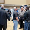 Attendees speak with employer representatives at informational tables during a job fair inside Fletcher Technical Community College.