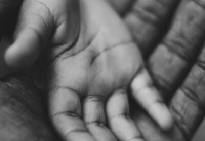 Grayscale Photo Of Baby's Hand On An Adult's Hand by Scopio from NounProject.com