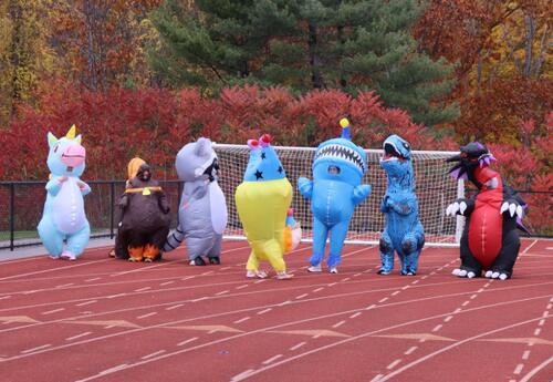 ORHS staff and faculty wearing inflatable costumes getting ready to race on the athletic field.