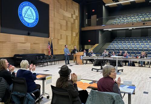 A photo of Dan Couture receiving his award in front of a large audience in the Morse Recital Hall.