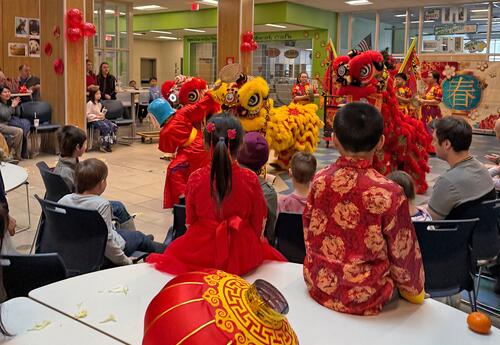Students, staff and families watch the Spring Festival lion dance at Oyster River Middle School.