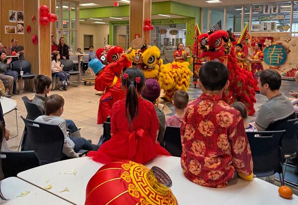 Students, staff and families watch the Spring Festival lion dance at Oyster River Middle School.