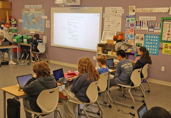 Students writing letters to their French pen pals in Ms. Pennelli's classroom.