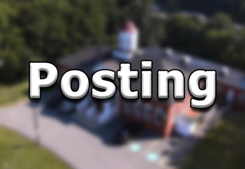 Blurred image of the district office with the word Posting overlayed.