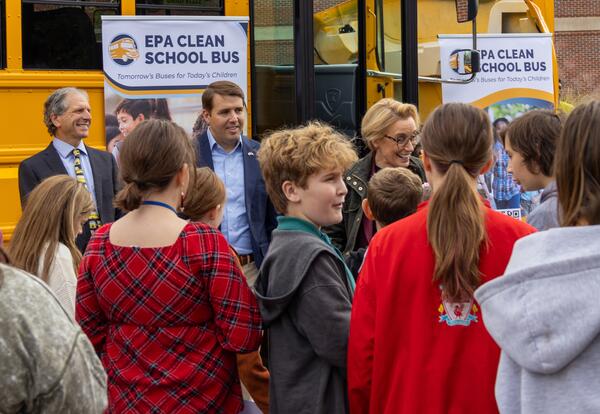 Senator Hassan, Representative Pappas, Administrator Nash with children in front of new electric bus