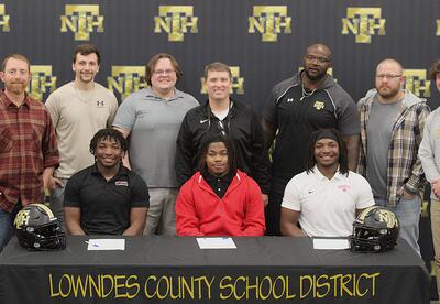New Hope High School football coaches with seniors Tariq Butler, Jeremiah Harkins and Micah Butler