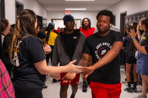An SBEP senior gives a high five to a teacher as he walks by. 