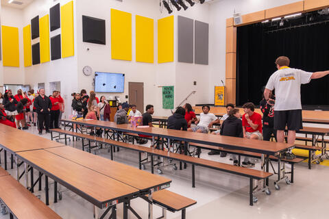 A teacher at St. Bernard-Elmwood Place stands on a table and provides instructions to students participating in the senior walk. 