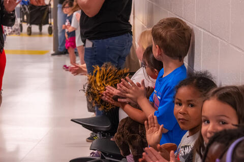 Elementary students watch and clap for the class of 2025 as they walk down the hallways. 