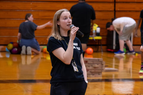 A teacher speaks into a microphone. 