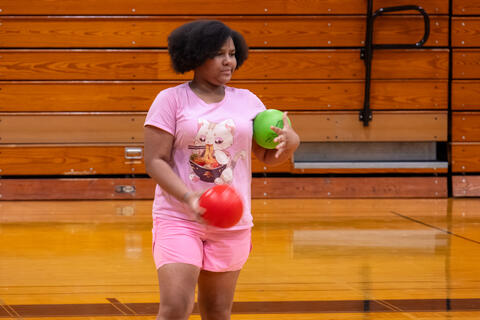 An eighth-grade student stands and looks ready during a game of dodgeball. 