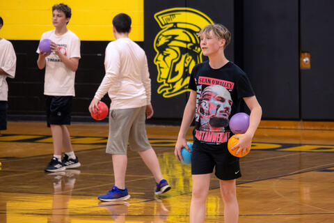 An eighth-grade student smiles during a game of dodgeball. 
