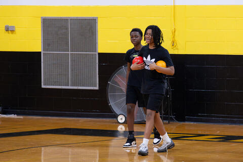 An eighth-grade student grins during a game of dodgeball. 