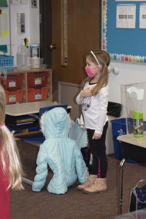 A Roosevelt student joins classmates in the Pledge of Allegiance as in-person learning returns on Jan. 19.