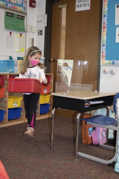 A Roosevelt first-grader brings supplies to her desk as in-person learning returns on Jan. 19.