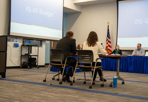 D64 admin sit down to give a presentation on the budget