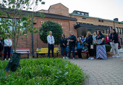 Dozens of people gathered around the tree on Monday, forming a circle as the sun rose over the school.