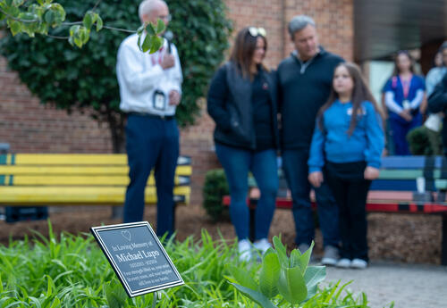 Dozens of people gathered around the tree on Monday, forming a circle as the sun rose over the school.