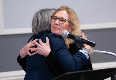 Colleagues hug during Retiree Dinner