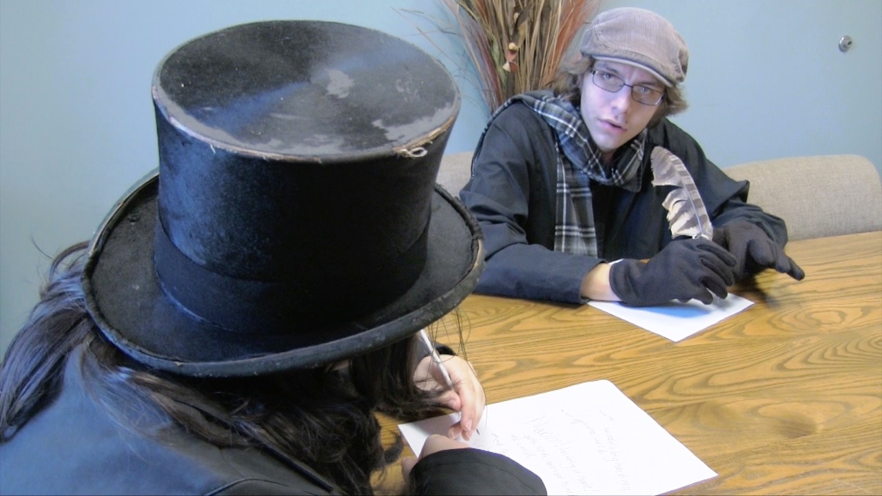 Two students dressed in Dickens costumes working on a theater performance