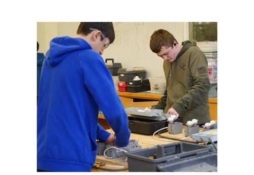Two KHS male students in the working on wiring an outlet