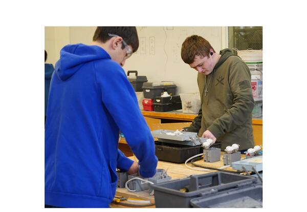 Two KHS male students in the working on wiring an outlet