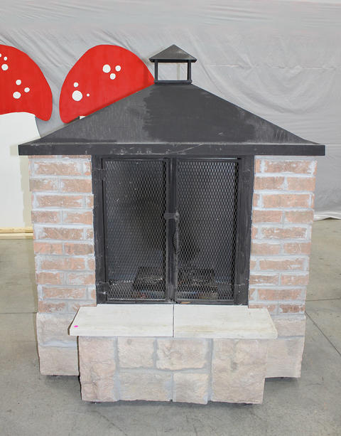 Brick and stone outdoor fireplace with glass doors.