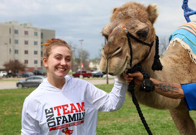 CCC student poses with a camel during the Over the Hump Midweek Bash on April 1st.