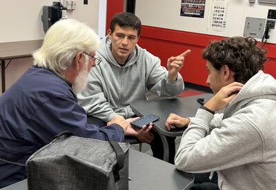 CCC students helping senior community members learn how to understand and use their cellular devices.