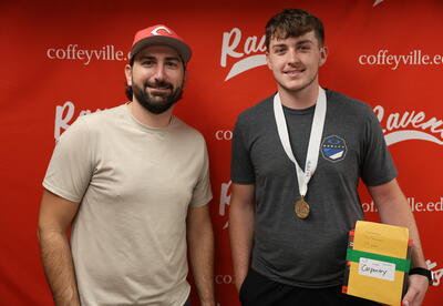Construction Technology Instructor Clint West poses with Rylan Allen of Neodesha as Allen displays his first-place medal and prize from the Kansas SkillsUSA State Conference individual carpentry competition.
