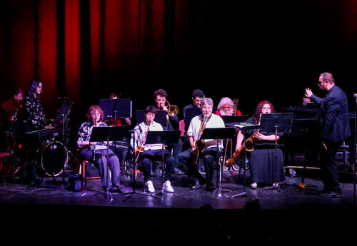 CCC Band Director Aaron Burke conducting the CCC band onstage.